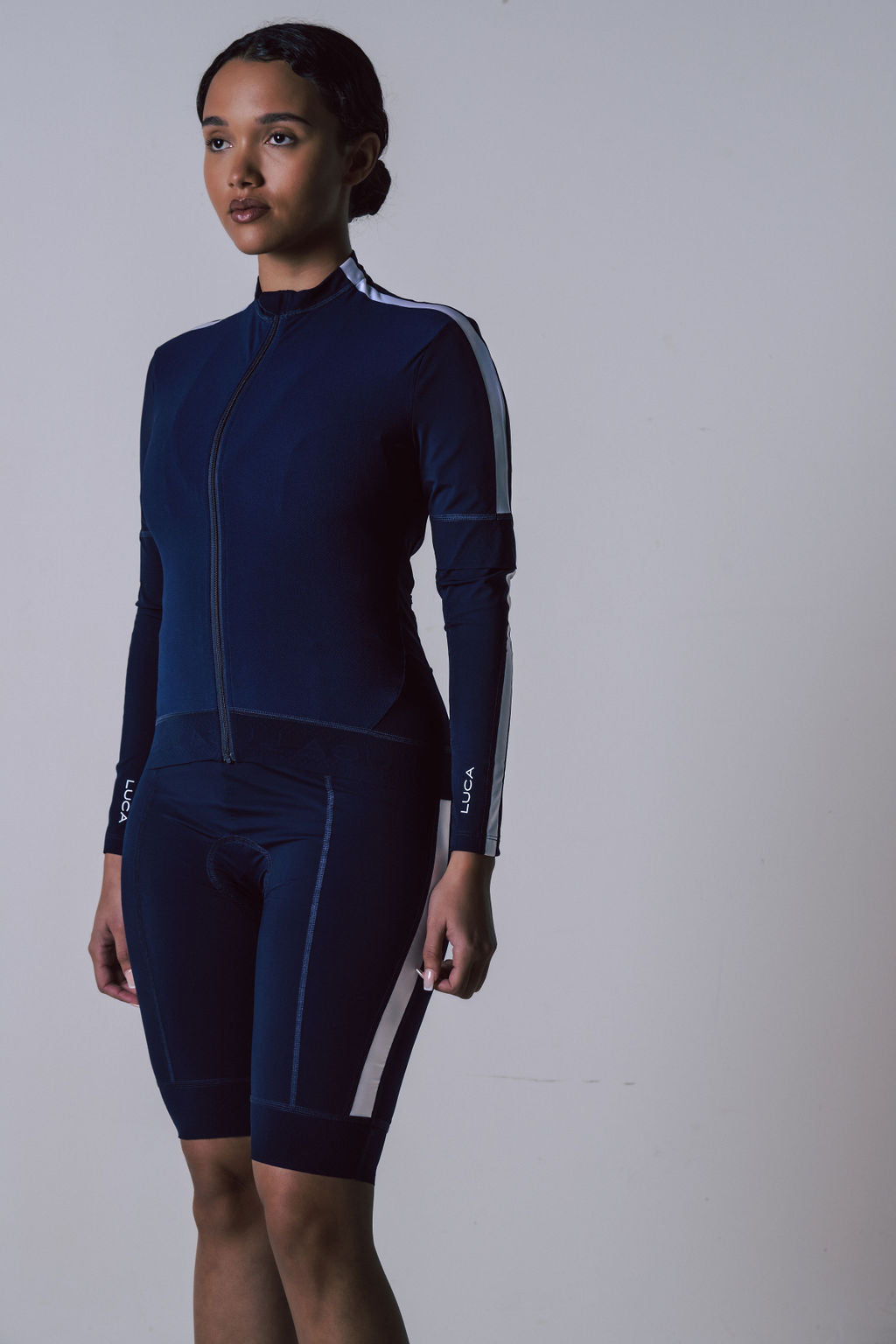 Women's-navy-blue-long-sleeve- cycling-kit-with-white-reflective-arm-and-leg-stripes-and-LUCA-logo-detail