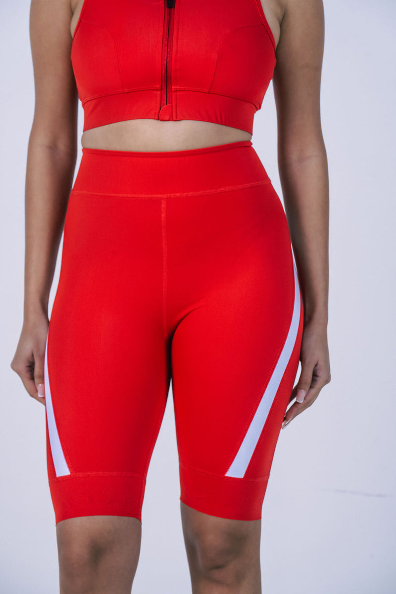 Product-photo-of-bright-red-high-waisted-biker-shorts-displayed- against-a-white-background-The-shorts-feature-a-modern-design-with-a-wide-white-diagonal-stripe-accent- on-the-outer-lower-leg-Focus-on-red- women's-biker-shorts-high-waist- cycling-shorts- athletic-workout-gear-and-running- shorts