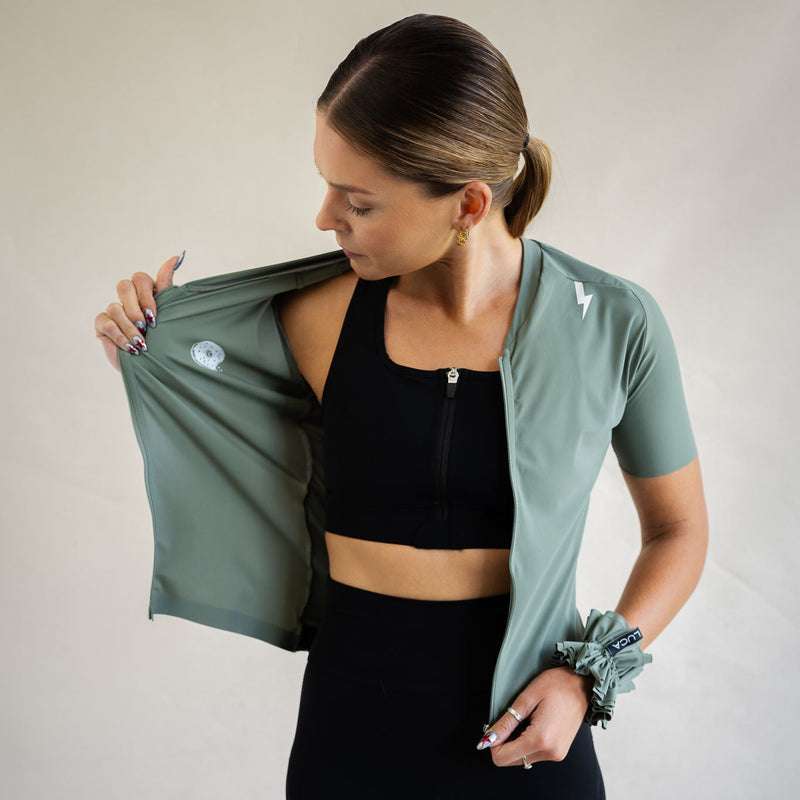 Cyclist in LUCA Soleil jersey in matcha, three-quarter side view